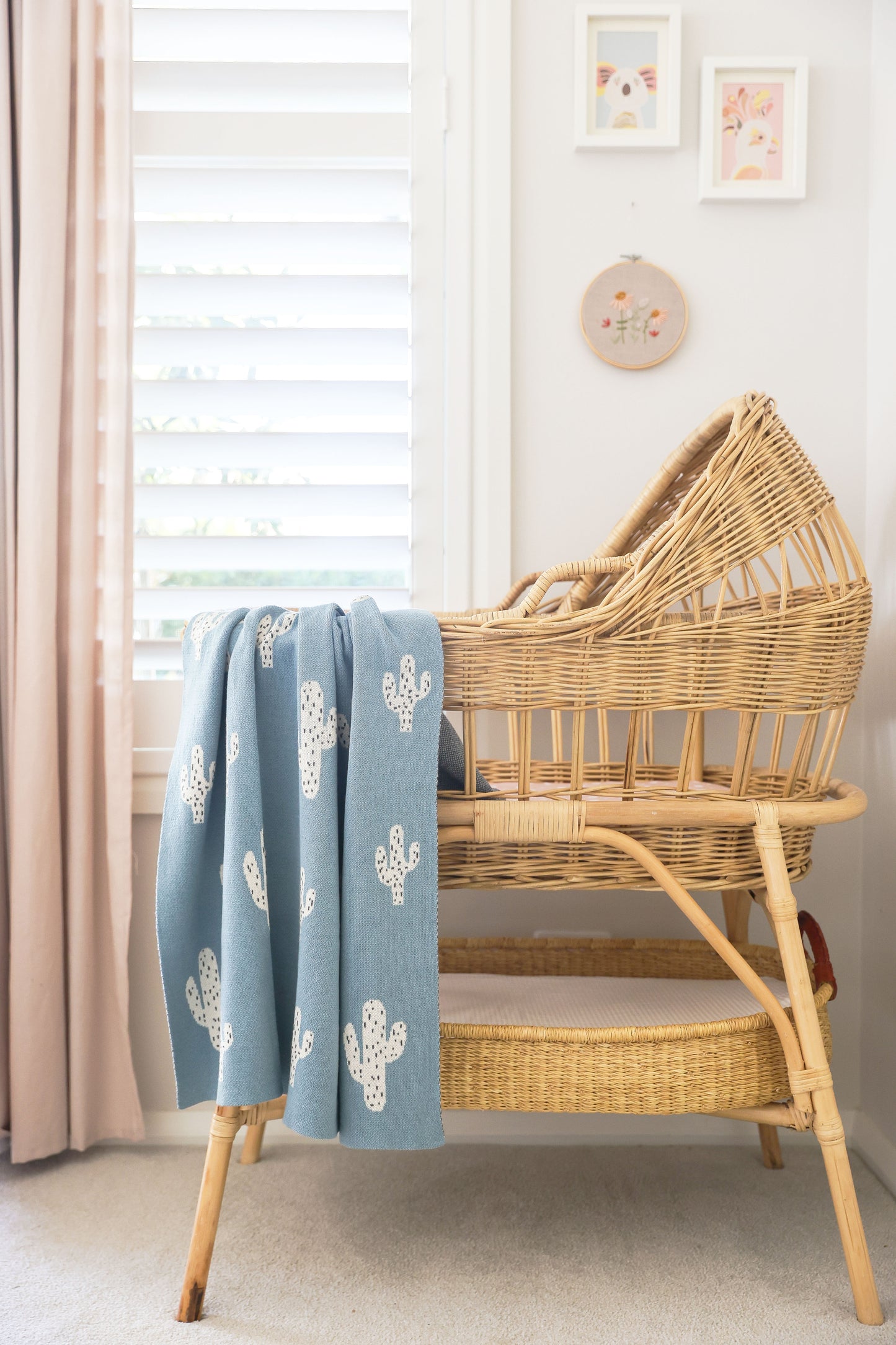 Cactus baby blanket in blue on a wicker bassinet, showcasing a unique and adorable design perfect for nurseries.