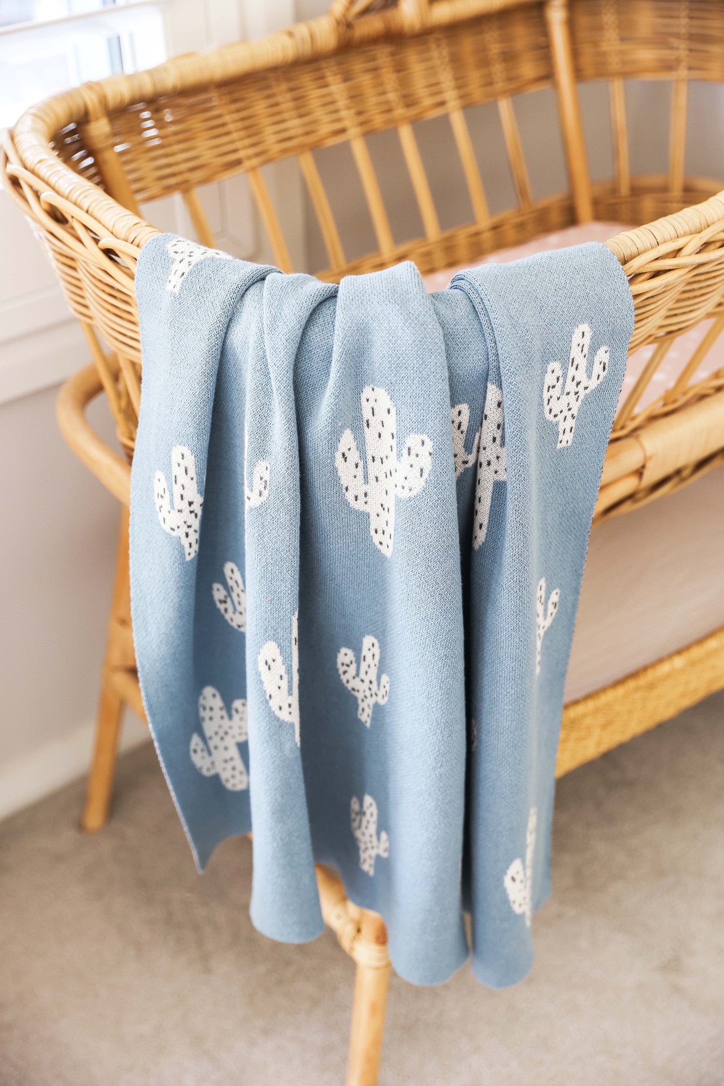 Lightweight cotton baby blanket in blue with cactus design, perfect for nursery decor, machine washable, 100cm x 80cm.