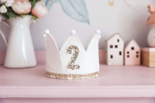 Ivory linen 2nd birthday crown with gold sequins and ribbon ties, perfect for toddler celebrations.
