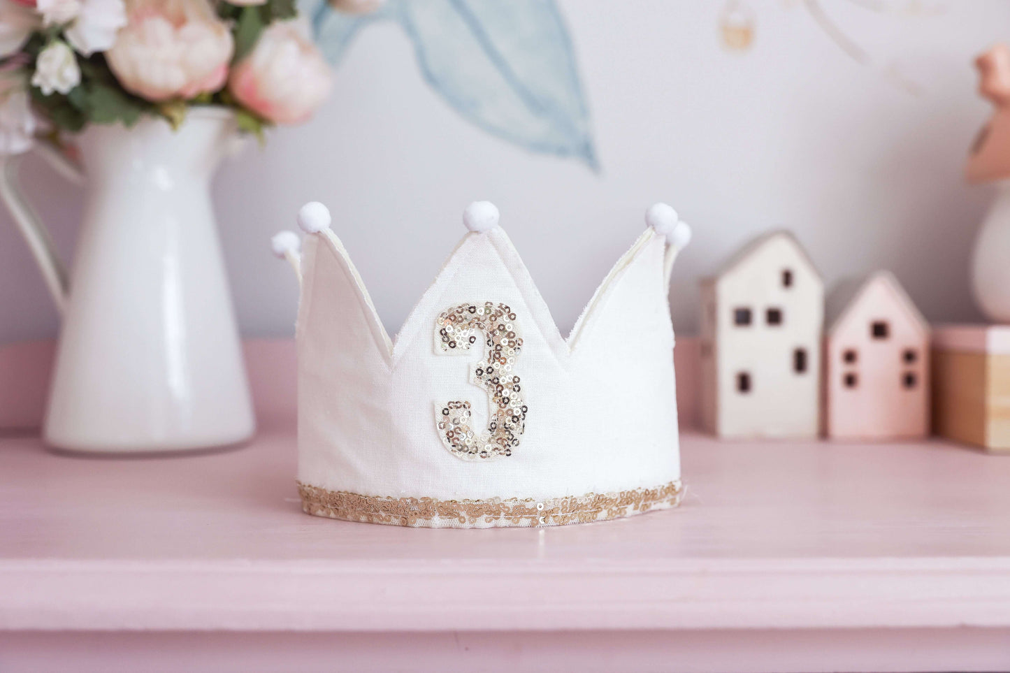 Ivory linen adjustable crown for 3rd birthday, featuring gold sequins and pom-poms, perfect for little celebrations.