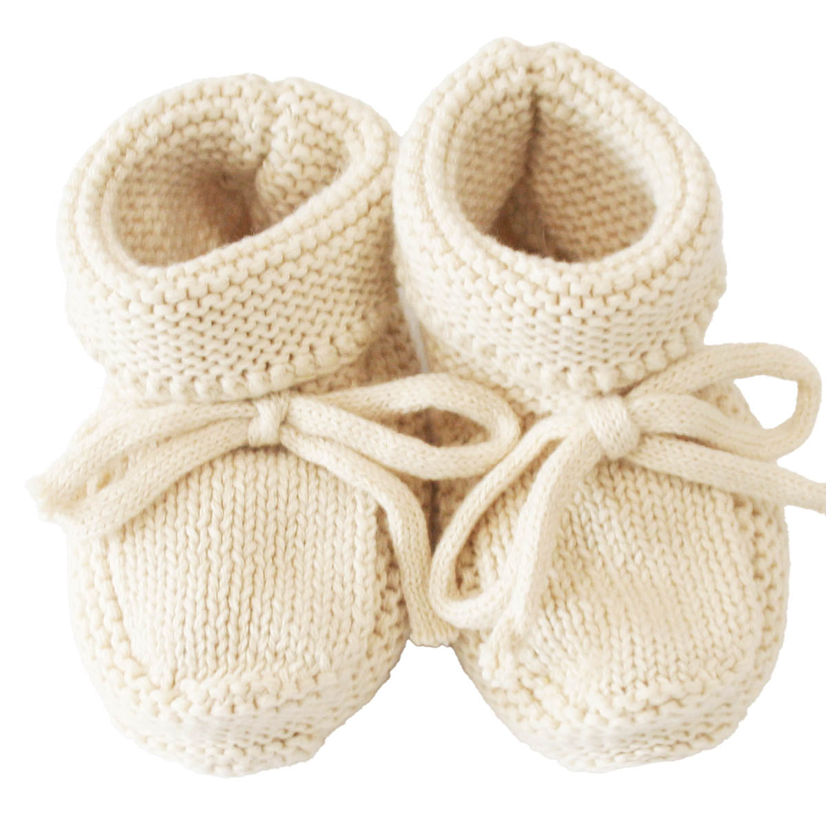 Cream-colored knit baby booties with folded cuffs and tied bows, soft wool material.