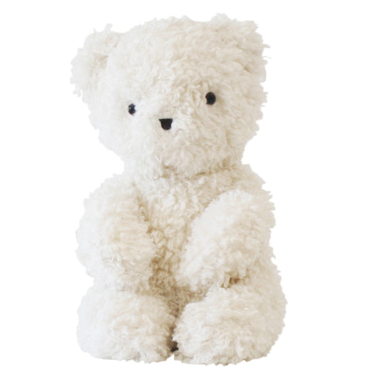 Ivory plush teddy bear with curly fur, black embroidered eyes and nose, sitting upright.