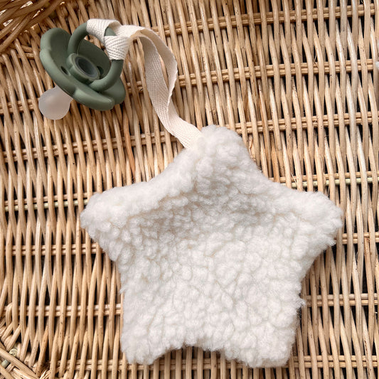 Ivory sherpa star comforter with pacifier attachment, perfect for soothing babies.