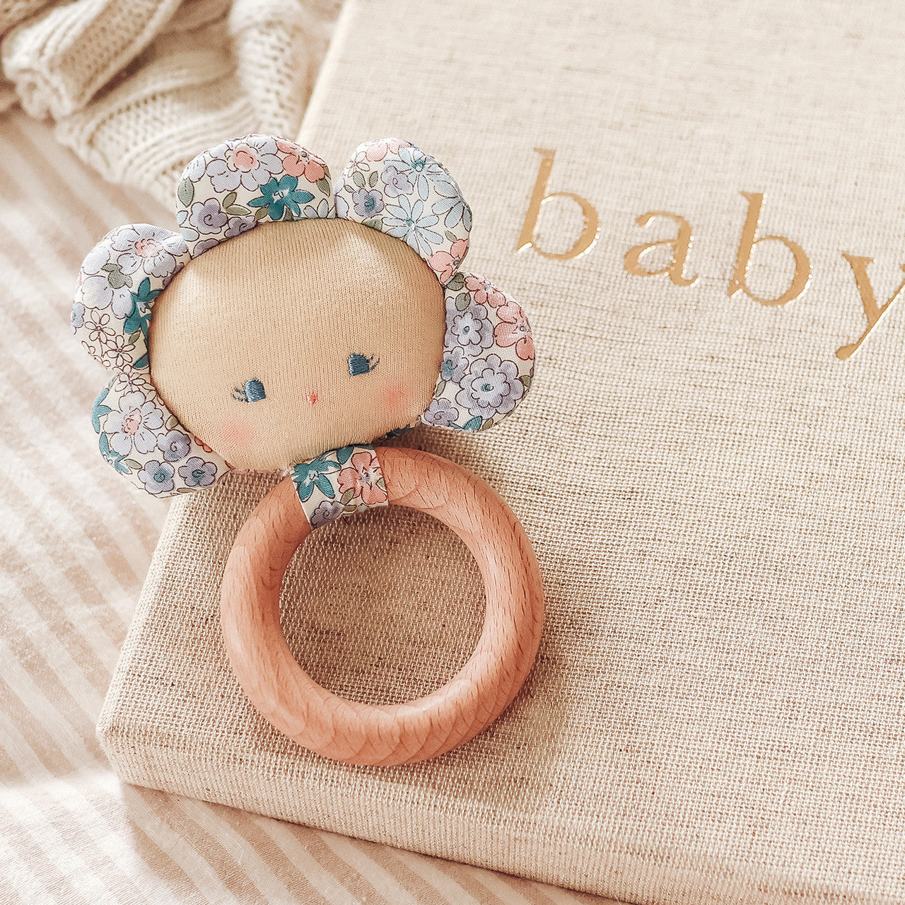 Flower Baby Teether Rattle Liberty Blue with natural beechwood ring and flower doll face, perfect for infants 3 months and up.