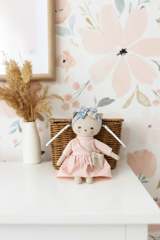 Mini Lilly Kitty doll in pink linen dress with floral headband, perfect for playdates and imaginative fun.