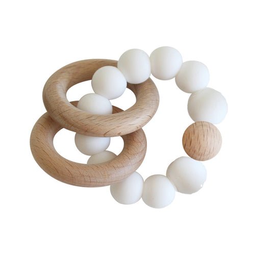 Beechwood teether ring set in milk, featuring smooth wood and soft silicone beads for sore gums.