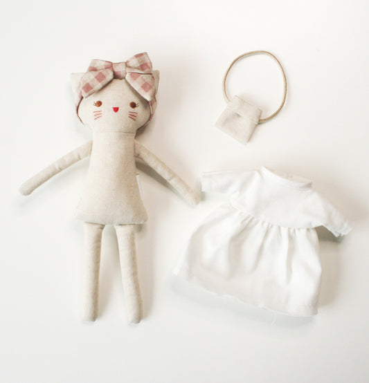 Mini Lilly Kitty doll with ivory dress and checked headband, includes removable dress and bag, ideal for playtime.