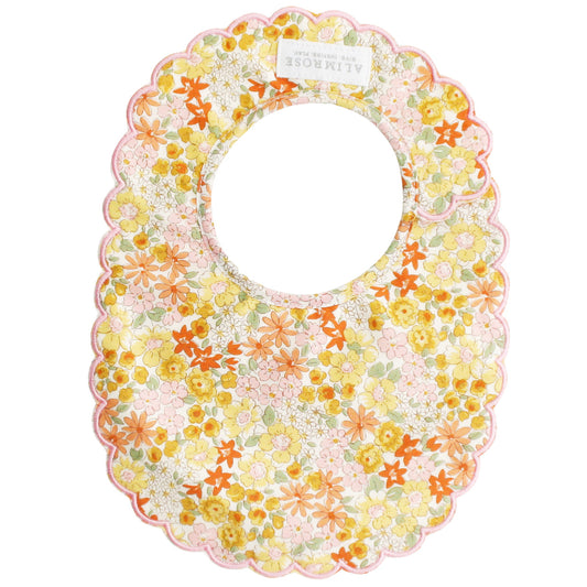 Alimrose Scallop Bib in Sweet Marigold, featuring floral design, cotton material, and Velcro closure for toddlers.