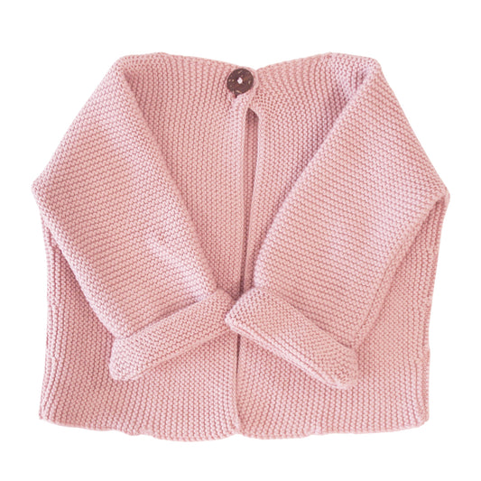 Soft pink knitted baby jacket with long sleeves and a single dark button closure at the neck.