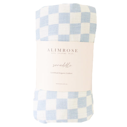 Blue and white checkered organic cotton swaddle blanket rolled with cream-colored label.