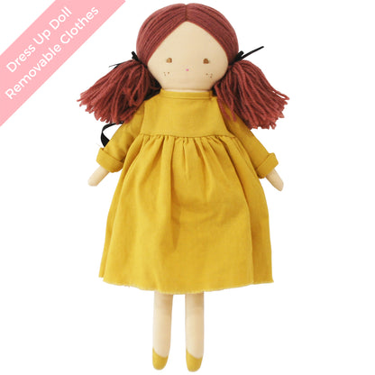 Cloth doll with red yarn hair in pigtails wearing a mustard yellow dress and matching shoes.
