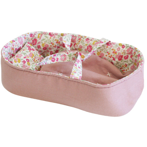 Pink fabric doll carrier with floral interior and cross straps for securing dolls.