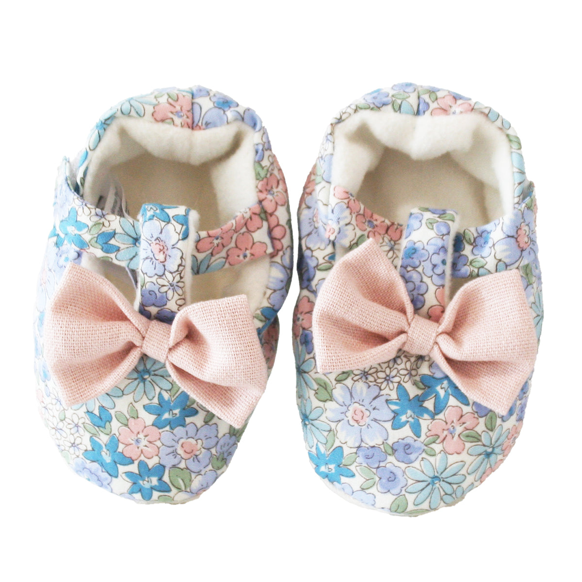 Soft fabric baby booties with pastel floral print and large pink bows on top.