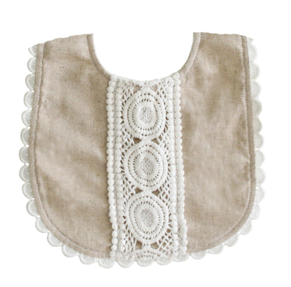 Natural linen baby bib with scalloped lace edging and oval lace details down the center.