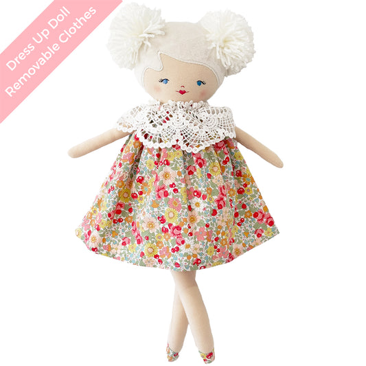 Cloth doll with yarn hair in two pom-poms, blue embroidered eyes, floral dress with white lace collar, soft fabric limbs.