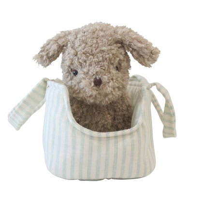 Soft brown plush puppy with floppy ears inside a light blue and white striped fabric carrier bag.