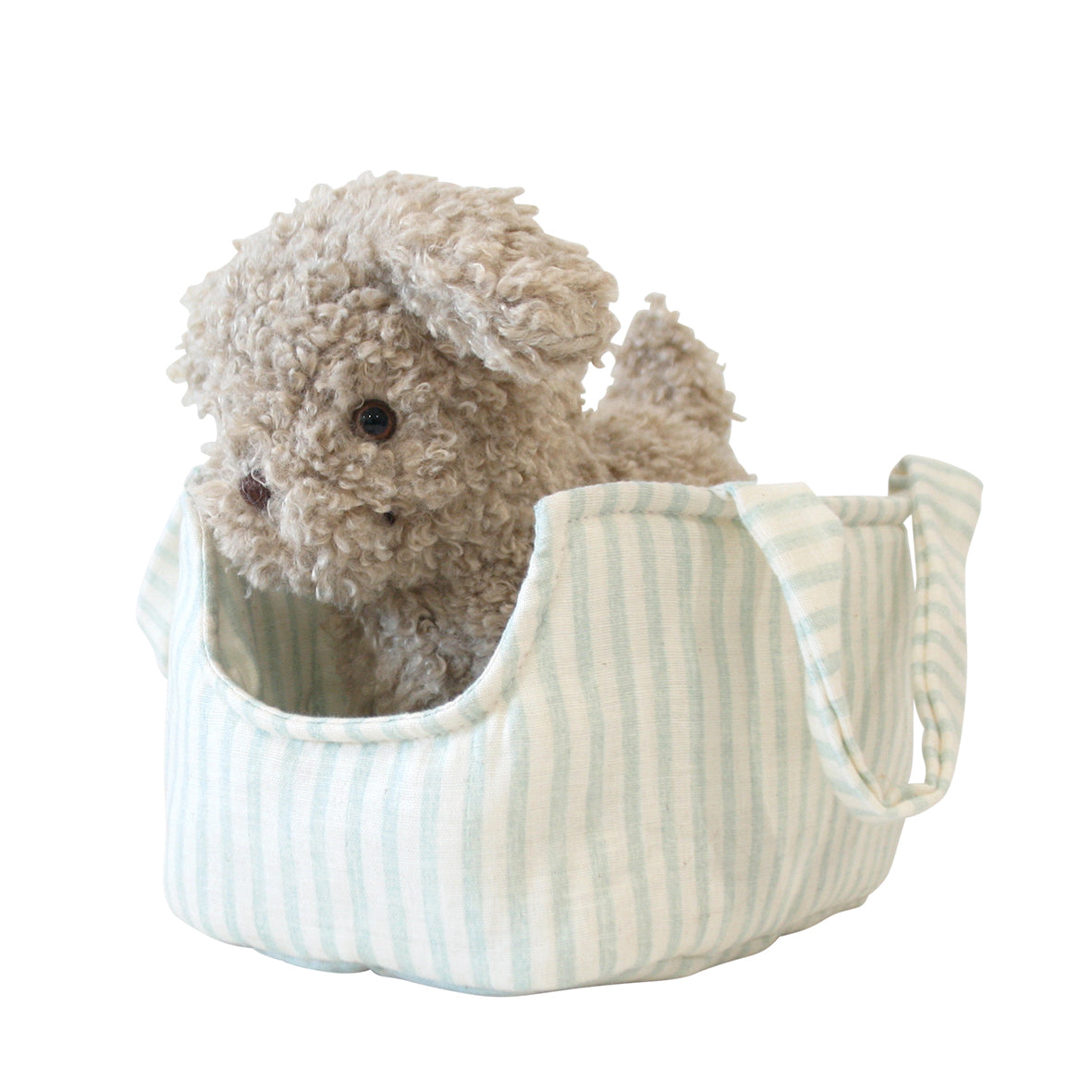 Soft beige plush puppy with curly fur sitting inside a light blue and white striped fabric carrier bag.