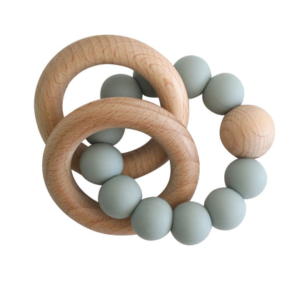 Beechwood teether ring with sage green silicone beads arranged in a circular pattern.