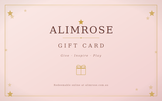 Pink rectangular gift card with gold stars border and text reading Alimrose Gift Card Give Inspire Play with a small gift.